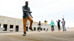 MS LA Group of friends watching man dancing in empty parking lot Stock Footage
