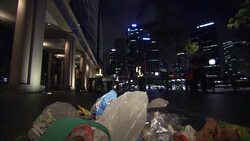 A city maintenance crew sweeps trash from a street in Sydney. Stock Footage