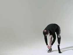 Athlete with prosthetic leg tying shoelace Stock Footage