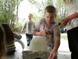 Boy leading group of young kids building a robot with recycled materials. Stock Footage