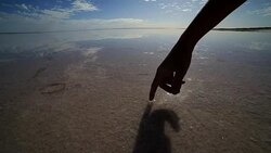 Finger touches surface of salted lake Stock Footage
