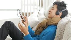 Teenager boy Enjoy Listening to Music on the sofa in relax time , Lifestyle and Relaxation concept , panning right to left movement Stock Footage