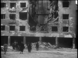 B/W 1939 tilt up people walking in front of bombed building after German invasion / Warsaw / documentary Stock Footage
