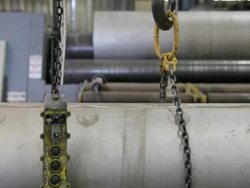 CU TU Swinging hook of crane ready to lifting large pipe in factory / Seattle, Washington, United States Stock Footage