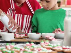 CU TU Grandmother and Granddaughter Decorating Gingerbread Men Cookies in Kitchen / Richmond, Virginia, USA Stock Footage