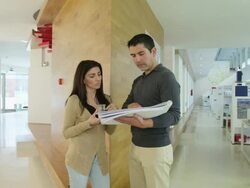 WS  man and woman standing in modern architect's office, discussing plans Stock Footage