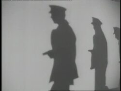 Police officers carrying guns cast shadows on a wall. News Clip