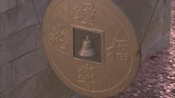 Winds cause a bell and gold shield to  sway at the Bai Yun Guan Temple in Beijing. Stock Footage