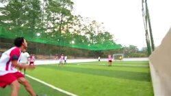 Soccer ball bounces off wall, defender heads it out of danger in local football match Stock Footage