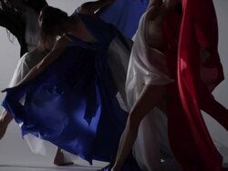 three woman dancers dancing, draped with colors of silk fabric that move with them Stock Footage