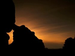 Turret Arch silhouetted in front of nice sunset with wispy clouds and deep colors Stock Footage