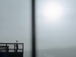 Wide shot boy dribbling soccer ball on footbridge / traffic passing in foreground Stock Footage