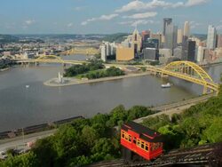 WS View of Pittsburgh Pennsylvania from Mt Washington hill looking at Golden Triangle and city skyscrapers where three rivers and red incline cars coming down mountain / Pittsburgh, Pennsylvania, United States Stock Footage