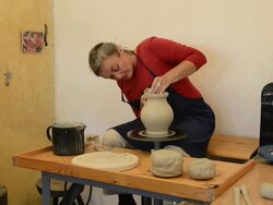 MS Shot of female potter finishing and smoothing out pitcher on potterwheel at pottery / Landshut, Bavaria, Germany Stock Footage