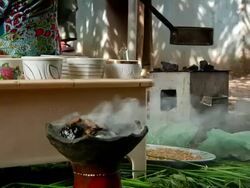 Incense burning while woman roasts coffe grainse in the background for coffee ceremony Stock Footage
