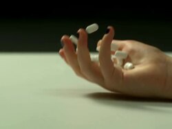 High speed Young lady's hand falls and drops white pills, split background Stock Footage
