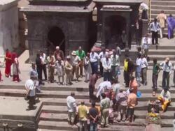  MS TD Large crowd brightly dressed observing from high ledge to  funeral of  deceased woman  / Kathmandu, Central, Nepal Stock Footage