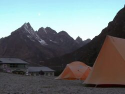 Yellow tents near buildings in the shadow of the Himalayas. Stock Footage