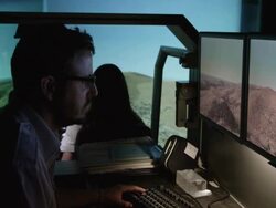 WS PAN RF instructor and student pilots in helicopter flight simulator during simulated flight over mountainous terrain; focus changes from instructor to students and instrument panel, RED R3D 4K Stock Footage