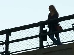 Women looks over  the Highline park in New York.  People walk behind Stock Footage