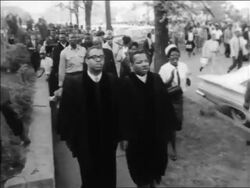 B/W 1963 high angle PAN Black clergy leading marchers in civil rights demonstration / Alabama / newsreel Stock Footage