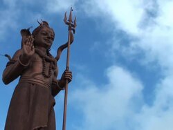 Light and shade play on big Shiva statue against sky Stock Footage