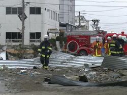 Destruction caused by tsunami after magnitude 9 Tohoku earthquake, north east Japan, March 2011. Fire crews walk over debris in Ishinomaki City,  Miyagi Prefecture Stock Footage