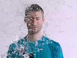 MS SLO MO Shot of Caucasian male against white canvas and water being thrown on him / Studio, New York, United States Stock Footage