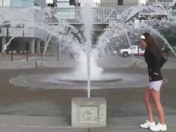 MS SLO MO Shot of young female jogger stretches at city fountain / Portland, Oregon, United States  Stock Footage