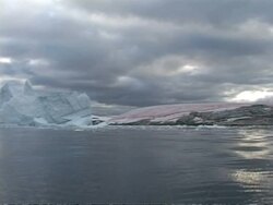 WA pink dimpled ice formation, yellow & grey clouds, Antarctica Stock Footage
