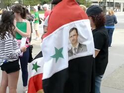 Protesters wear Syrian flags with al-Assad photo Stock Footage