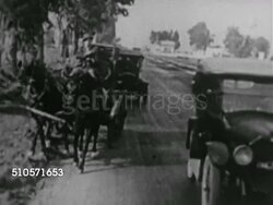 1920s: EARLY ROADS: Firemen w/ hook & ladder truck pulling / pushing Firestone delivery truck out of soft sand road, VS Large trucks driving on muddy roadway, larger trucks on soft dirt uphill road. Instructional Video