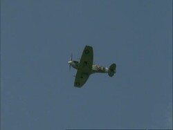 MS Supermarine Spitfire flies past overhead in blue sky, England, UK Stock Footage