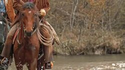 TD Herdsmen and herdswoman riding horses across river Stock Footage