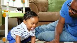 MS Father playing with infant son on living room floor Stock Footage