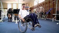 Portrait smiling man in wheelchair with physical therapist in background Stock Footage