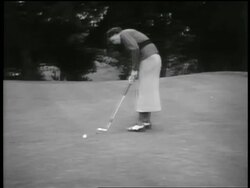 B/W 1930s PAN female golfer (Babe Didrikson) putting ball into hole Stock Footage