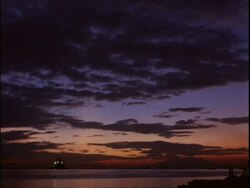 WA view across rippling water, Silhouetted fishing boat on horizon, colourful, atmospheric dusk sky, Manila bay, Philippines Stock Footage