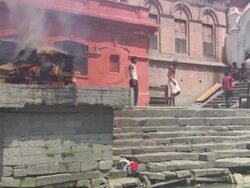 WS Community observes as  body burns under wood during  traditional cremation process AUDIO / Kathmandu, Central Region, Nepal Stock Footage