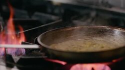 Corn succotash sizzles over flaming gas stove in restaurant kitchen Stock Footage