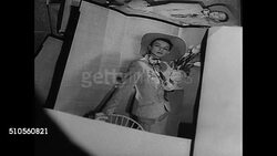 1947: VOGUE PHOTO LAYOUT: CU Photographs on table of models posing. INT MS Art layout editors in office looking at pictures. MS Laying out page of Vogue. MS Vogue magazine opening to completed page. NYC Instructional Video