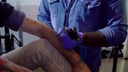 Serious man receiving tattoo from tattoo artist Stock Footage