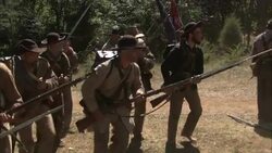 Confederate soldiers march across a field, leaving the dead. Stock Footage