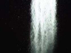 CU SLO MO Shot of Wide spray of water moving through frame against black background / United Kingdom Stock Footage