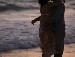 Good Looking Young Couple embracing in front of the Sea at sunset Stock Footage