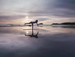 WS POV Woman doing yoga on beach / Bandon, OR, United States  Stock Footage