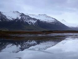WS View of snow mountain reflection in lagoon / Iceland Stock Footage