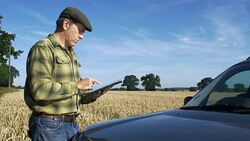 Farmer in field using digital tablet computer. Stock Footage