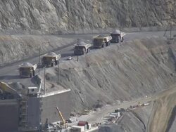 dump trucks dumping rock into in pit crusher Stock Footage