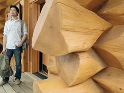 Young man arriving at log cabin Stock Footage